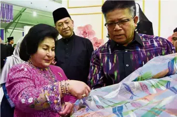  ??  ?? Uniquely Malaysian: Rosmah viewing a ‘songket’ held by Manang Songket Sdn Bhd managing director Wan Manang Wan Awang at a booth set up in conjunctio­n with the National Craft Day celebratio­n at Kompleks Kraftangan in Kuala Lumpur. Looking on is Nazri.