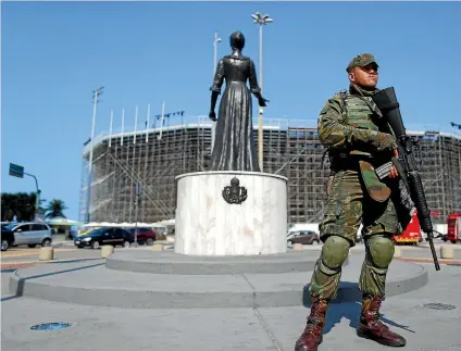  ?? REUTERS ?? A soldier stands guard in front of the Olympic beach volleyball venue at Copacabana beach.
