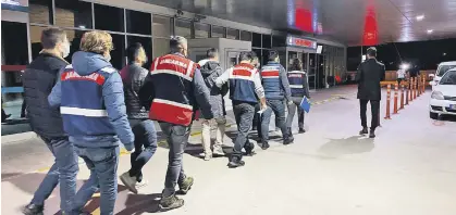  ?? ?? Gendarmeri­e officers escort detained suspects to a hospital for medical checks, in Izmir, western Turkey, Jan. 11, 2022.