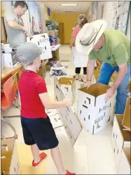  ?? COURTESY PHOTOS ?? Left: Margo Hale with her daughters, Esther and
Clara, get food boxes ready at Prairie Grove United Methodist Church. The church is providing food to those in need every Saturday. Josh Hale is in the background. Right: Members of Prairie Grove United Methodist Church assemble boxes for food. The church has been providing food during the covid-19 pandemic since March.