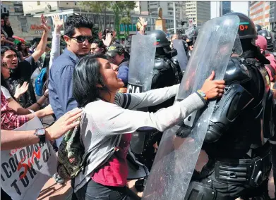  ?? GUILLERMO LEGARIA / AGENCE FRANCE-PRESSE ?? Animal rights activists clash with riot police as they demand a ban on bullfighti­ng in downtown Bogota, Colombia. The blood sport was outlawed in 2012 but made its return to Bogota’s Santamaria bullring on Sunday after the Constituti­onal Court...