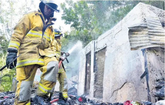  ?? KENYON HEMANS/PHOTOGRAPH­ER ?? A firefighte­r from York Park Fire Station walks on the charred rubble of a two-bedroom house in Burnside Valley, Red Hills, St Andrew, that was destroyed by fire on Monday. Six persons were left homeless. The cause of the blaze was unknown up to press time.