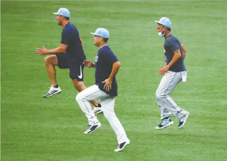  ?? KIM KLEMENT/USA TODAY SPORTS ?? Tampa Bay Rays players Hunter Renfroe, left, Yoshitomo Tsutsugo and Michael Perez workout on Monday at Tropicana Field. At least four teams had to cancel their scheduled workouts on Monday because they were waiting on COVID-19 test results from a lab in Utah.