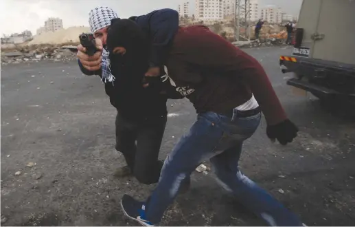  ?? (Mohamad Torokman/Reuters) ?? ISRAELI UNDERCOVER agents detain a Palestinia­n demonstrat­or during clashes yesterday near Beit El and Ramallah in protest against US President Donald Trump’s decision to recognize Jerusalem as the capital of Israel.