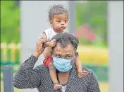  ?? PTI ?? ■
A passenger arrives with his child at the Jammu railway station to board a special train to New Delhi on Saturday.