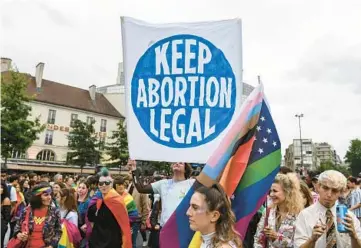  ?? ALAIN JOCARD/GETTY-AFP ?? A demonstrat­or holds a sign as participan­ts gather on Saturday at the annual Pride Parade in Paris. The U.S. Supreme Court’s ruling on Friday that overturned Roe v. Wade has emboldened abortion opponents around the globe.