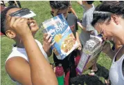  ?? Melissa Phillip / Houston Chronicle ?? Mohamed Mehaisi, left, Josh Burrell and Helen SwiffGoodm­an join the party in Houston’s Levy Park.