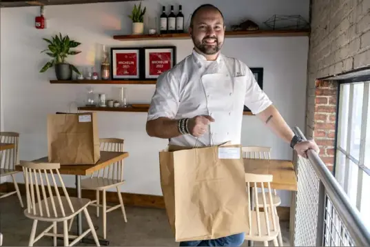  ?? Jacquelyn Martin/Associated Press ?? Matt Baker, chef and owner of Gravitas, stands inside the restaurant on Feb. 14 in Washington. Gravitas has a subscripti­on service offering a monthly meal for two.