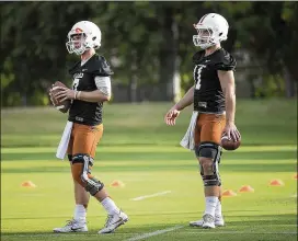  ?? RALPH BARRERA / AMERICAN-STATESMAN ?? Quarterbac­ks Shane Buechele (left) and Sam Ehlinger (right) go through drills Monday during the Longhorns’ first day of training camp.