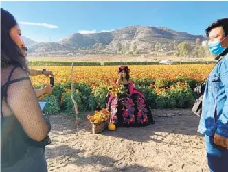  ?? ALEXANDRA MENDOZA U-T ?? A woman in traditiona­l dress poses during a photo shoot at Tijuana’s Cempasuchi­l Tijuana flower field.