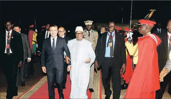  ?? LUC GNAGO / AFP ?? Emmanuel Macron camina junto al presidente maliense, Ibrahim Bubacar Keita, a su llegada ayer al aeropuerto Modibo Keita de Bamako