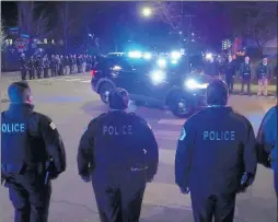  ?? JOHN J. KIM/CHICAGO TRIBUNE ?? Chicago police officers stand in formation as a procession for a Chicago police officer reaches the Cook County medical examiner on Friday. A 38-year-old officer with 15 years of service died by apparent suicide earlier in the evening, according to police.