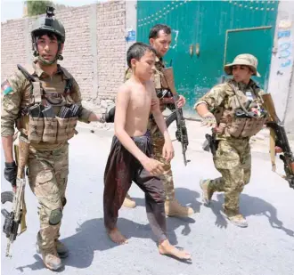  ??  ?? Security forces escort a slightly injured boy at the site of gunfire and attack in Jalalabad city on Wednesday. — Reuters