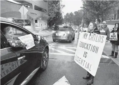  ?? MATTBUTTON/BALTIMORE SUNMEDIA ?? Teachers and their supporters participat­e in the Harford County Education Associatio­n car caravan, left, while other groups advocate for the reopening of Maryland schools during a Harford County Board of Education meeting Dec. 21.