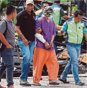  ?? PIC COURTESY OF READER ?? Cops taking the suspect to the crime scene in Tanjung Sepat yesterday.