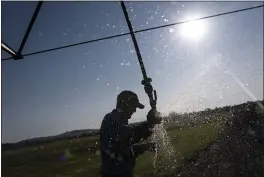  ?? NATHAN HOWARD — THE ASSOCIATED PRESS ?? Matt Lisignoli shuts off an irrigation sprinkler at his farm Smith Rock Ranch in the Central Oregon Irrigation District in Terrebonne, Ore., on Tuesday,