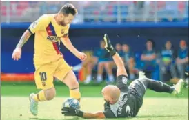  ?? AFP ?? Barcelona's Lionel Messi (L) challenges Eibar's goalkeeper Marko Dmitrovic during a La Liga game.