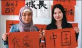  ?? REN QI / CHINA DAILY ?? Eurasian University students Zhuassova Assem (left) and Gazizova Guldana show on Thursday their Chinese calligraph­y works, which together say “I Love China”.