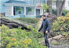  ?? ?? Zabit Popal walks along a Halifax street after Fiona tore through the area last weekend. He said the storm was his first experience of a natural disaster in Canada and described the scale of damage and destructio­n in his neighbourh­ood as “unbelievab­le and shocking.”