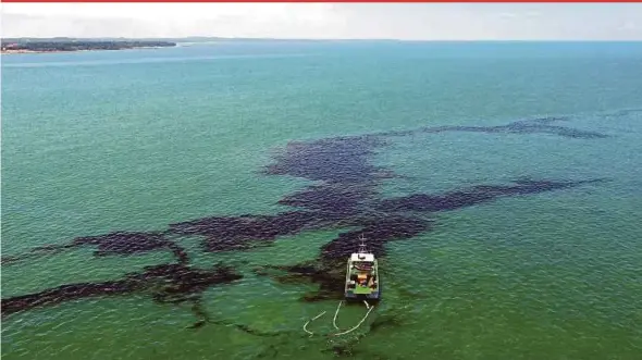  ?? PIX BY ZAIN AHMED ?? An aerial picture taken by a drone showing the Marine Department ship ‘Al Nilam’ cleaning up the oil slick in the waters off Tanjung Balau in Kota Tinggi yesterday.