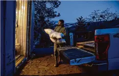  ?? ?? Richard Green, a revegetati­on worker with Yurok Fisheries, carries a sack of seeds from 19 different native species that will be planted along the exposed shoreline of Iron Gate Reservoir.