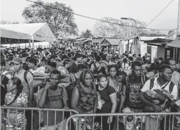  ?? FEDERICO RIOS The New York Times ?? Migrants await a bus ride north at Lajas Blancas, an official migrant camp in Panama, on March 7. Fourteen women alleging sexual assault were among 70 migrants who told The New York Times of being attacked in the Darién Gap.