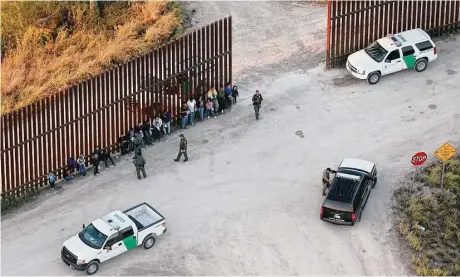  ?? Jerry Lara / San Antonio Express-News ?? Agentes de la patrulla fronteriza detienen a un grupo de inmigrante­s, incluidos varios niños, durante un operativo frente a la valla que divide a México y Estados Unidos, cerca de la localidad de Penitas, Texas, el martes 4 de octubre de 2016.