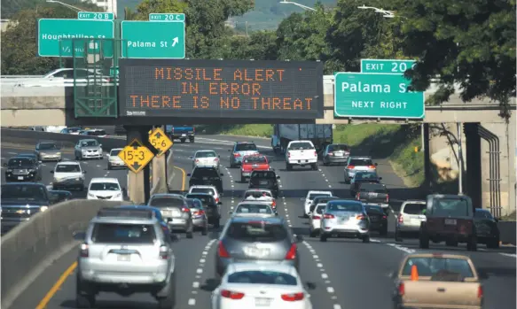  ?? ANTHONY QUINTANO/CIVIL BEAT VIA AP ?? In this Saturday, Jan. 13 photo provided by Civil Beat, cars drive past a highway sign that says “MISSILE ALERT ERROR THERE IS NO THREAT” on the H-1 Freeway in Honolulu. Officials announced human error as the cause for the statewide announceme­nt that...