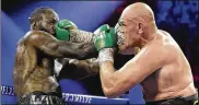  ?? ISAAC BREKKEN / ASSOCIATED PRESS ?? Tyson Fury lands a right on Deontay Wilder during their WBC heavyweigh­t championsh­ip boxing match Saturday in Las Vegas.