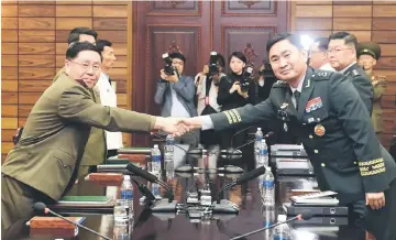  ??  ?? Do-gyun shakes hands with Il-san during their high-level miilitary talk at the northern side of the truce village of Panmunjom, in North Korea. — Reuters photo