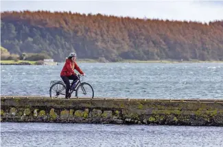  ??  ?? TOP The curving white sands of Helen’s Bay offered a beautiful beginning to Helen’s cycle tour ABOVE Helen travels the causeway leading to the ruins of 15th-century Sketrick Castle, on an island in Strangford Lough