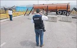  ?? FERNANDO VERGARA/AP ?? An immigratio­n official checks a fuel tanker, cargo trailers and makeshift fencing, used as barricades by Venezuelan authoritie­s to block humanitari­an aid from entering.