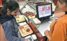  ?? Morgan Lee/Associated Press ?? A third-grader punches in a code to pay for a meal at Gonzales Community School in Santa Fe, N.M.