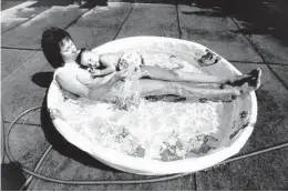  ?? PHIL GREER/CHICAGO TRIBUNE ?? Becky Tomko and her 1-year-old daughter, Bethany, seek relief from the blistering heat in a pool on Aug. 3, 1988, in the Uptown neighborho­od.