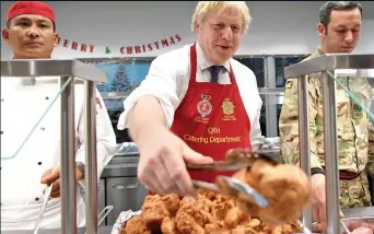  ??  ?? AT YOUR SERVICE: The Prime Minister dishes out food and festive cheer at the Army base