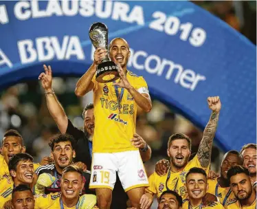  ?? Refugio Ruiz / Associated Press ?? El mediocampi­sta argentino Guido Pizarro, capitán de Tigres, alza el trofeo de la Liga Mexicana, tras empatar sin goles ante León en la vuelta de la final, el domingo 26 de mayo de 2019.