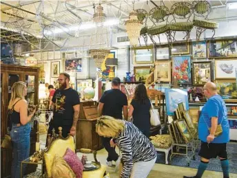  ?? LUIS SANTANA ?? Customers browse the thousands of items for sale during First Look Friday at the Vintage Marché Hive on July 1 in St. Petersburg.