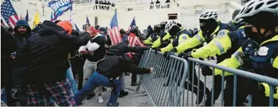  ?? JULIO CORTEZ/AP ?? Insurrecti­onists loyal to President Donald Trump try to break through a police barrier Jan. 6, 2021, at the U.S. Capitol.