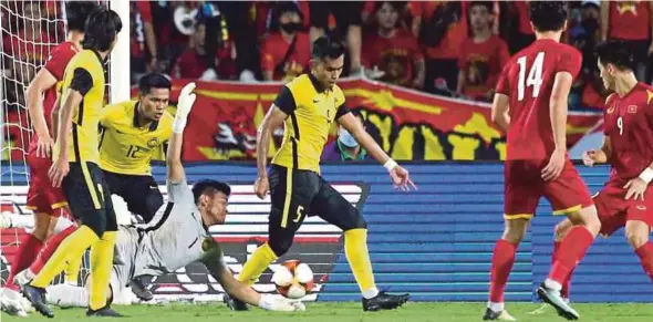  ?? ?? Malaysia goalkeeper Azri Ghani (in grey shirt) makes a save during their semi-final clash against Vietnam on Thursday in the Sea Games.