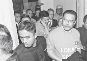  ?? — Gambar Bernama ?? TERTUDUH: Abdul Latiff (depan tengah, baju oren) bersama anaknya Ahmad Fauzan (tengah, baju oren) dan Amir (belakang tengah, baju oren) dihadapkan ke Makhamah Sesyen semalam atas 21 tuduhan di bawah Akta Pencegahan Pengubahan Wang Haram, Pencegahan...