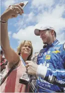  ?? AP PHOTO ?? SNAPPY: A fans takes a selfie with Dale Earnhardt Jr. as he signs autographs yesterday.