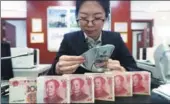  ?? ZHANG YUN / CHINA NEWS SERVICE ?? A clerk counts US dollars at a bank in Taiyuan, capital of Shanxi province.