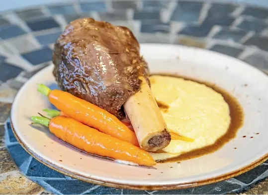  ?? KAVINDA HERATH/STUFF ?? A recipe designed for winter warmth: Black Garlic venison shank, cheesy polenta and seasonal vegetable.