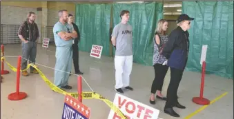  ?? The Sentinel-Record/Grace Brown ?? ELECTION DAY: People wait in line to vote Tuesday at the local polling station located at the Hancock Fabrics building, 4534 Central Ave., during the mid-term elections.