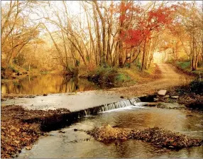  ?? Photo by Randy Moll ?? Fall colors provide photo opportunit­ies in scenic places such as the old Springtown low-water bridge on the Flint Creek.