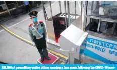  ?? — AFP ?? BEIJING: A paramilita­ry police officer wearing a face mask following the COVID-19 coronaviru­s outbreak stands guard outside the media centre before a news conference by the spokesman for the National Committee of the Chinese People’s Political Consultati­ve Conference (CPPCC) in Beijing.