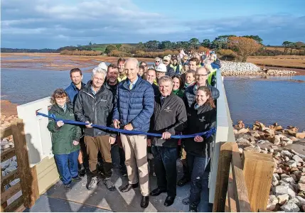  ?? Guy Newman ?? The son of the 22nd Baron Clinton, Lord Charles Rolle Fane Trefusis, cuts the ribbon to officially open the new footbridge on the South West Coast Path as part of the Lower Otter Restoratio­n Project at Budleigh Salterton