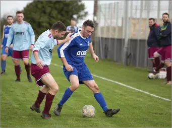  ??  ?? Charlie Maguire of St Anthony’s closes in on Glen Hughes of Roundwood.