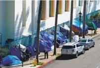  ?? NELVIN C. CEPEDA U-T ?? Tents form an encampment for homeless people on the sidewalk on Eighth Avenue near E Street in downtown San Diego.
