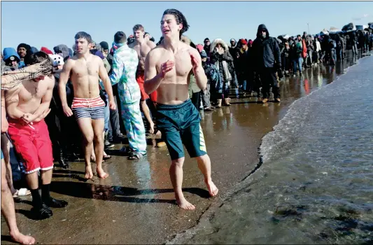  ??  ?? Polar Bear Club swimmers prepare to make their annual icy plunge into the Atlantic Ocean on Monday at Coney Island in the Brooklyn borough of New York City. The temperatur­e at the time of the swim was -8 C (17 degrees Fahrenheit).